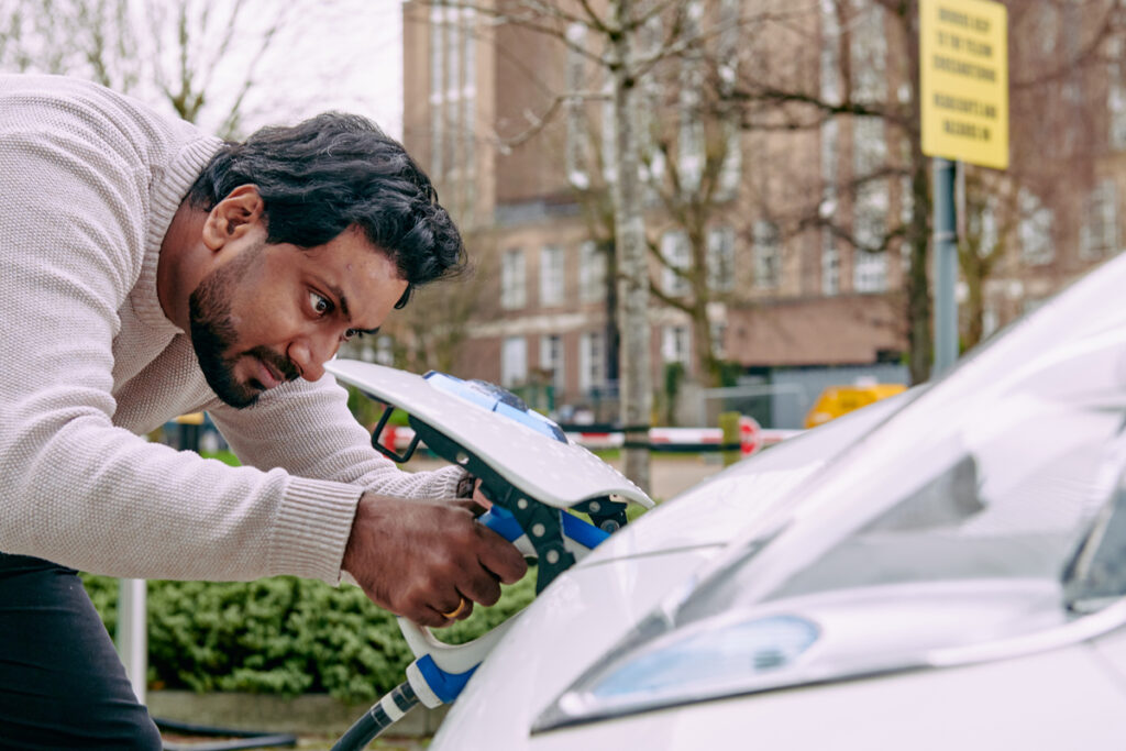 photo of a man fueling an electric vehicle