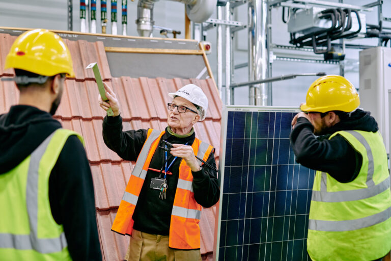 photo of workers in hard hats and high vis jackets in workplace for solar panel installation training